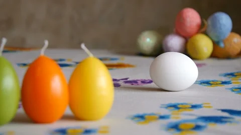 Easter. Female hand spin white egg on the table. Colorful Easter eggs in the Stock Footage 106146908
