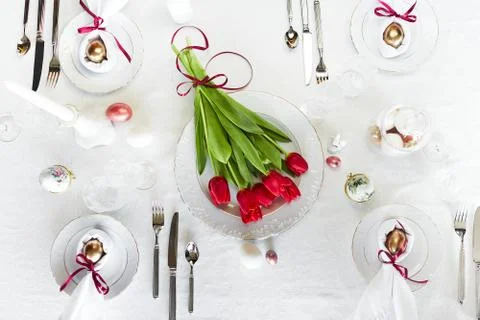 Easter festive spring table setting decoration, eggs in nest, fresh red tulips Stock Photos