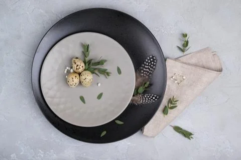 Easter  festive table setting with  gray plate, quail eggs leaf sprigs Stock Photos