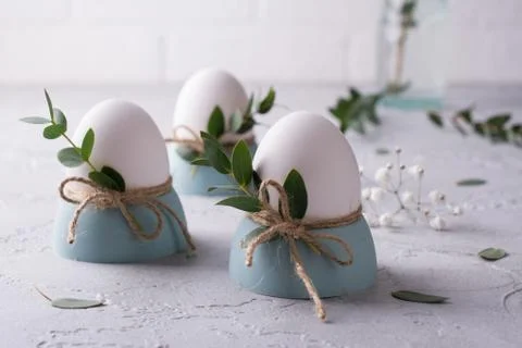 Easter  festive table setting with white chicken  eggs in eggs cups, leaf Stock Photos