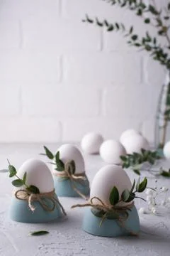 Easter  festive table setting with white chicken  eggs in eggs cups, leaf Stock Photos