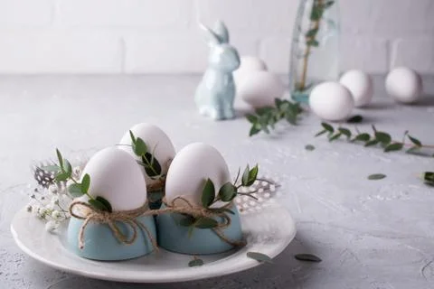Easter  festive table setting with white chicken  eggs in eggs cups, leaf Fotos de archivo