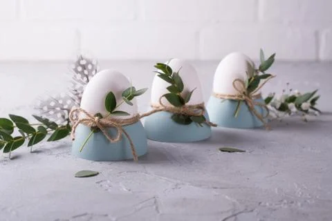Easter  festive table setting with white chicken  eggs in eggs cups, leaf Stock Photos