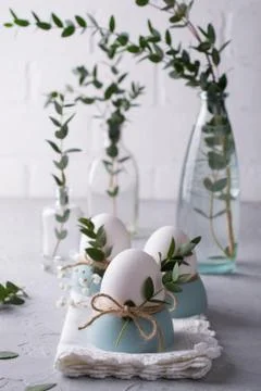 Easter  festive table setting with white chicken  eggs in eggs cups, leaf Foto stock