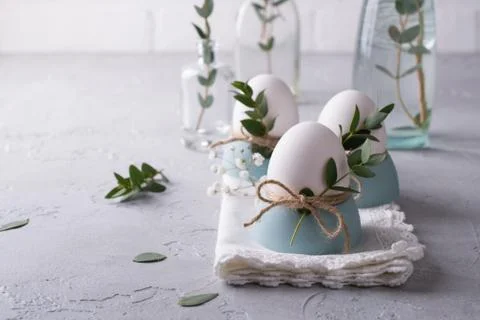 Easter  festive table setting with white chicken  eggs in eggs cups, leaf Stock-Fotos