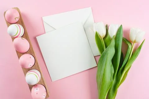 Easter flat lay composition. Easter eggs, empty card blank and white tulips.. Stock Photos