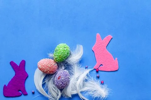 Easter flat lay composition. Two colored bright rabbits and painted eggs Stock Photos