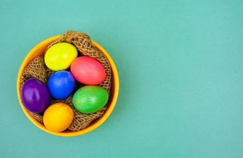 Easter Flat Lay with Multicolor Eggs in Rustic Bowl on Blue Background Foto stock