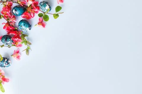 Easter flat lay. Stylish easter eggs and red flowers on blue background. Ea.. Stock Photos
