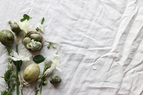 Easter flat lay. Stylish easter eggs in nest, daffodils flowers and cherry .. Stock Photos