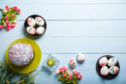 Easter flatlay composition with decorated eggs, flowers, burning candle Stock Photos