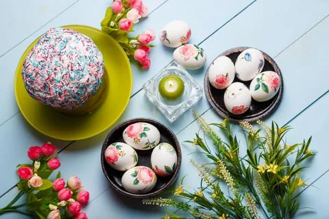Easter flatlay composition with decorated eggs, flowers, burning candle Stock Photos