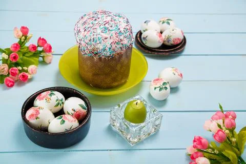 Easter flatlay with decorated eggs, flowers, burning candle and Easter bread Stock Photos