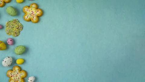 Easter flower biscuits and candy eggs on flat colored background .Easter holi Foto stock