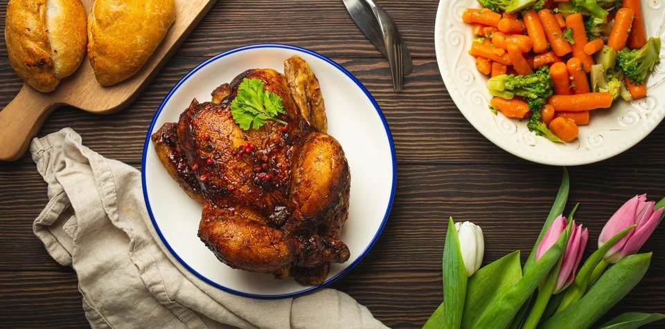Easter food on dark rustic table pastel colored eggs roasted chicken and Foto stock