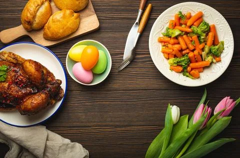 Easter food on dark rustic table pastel colored eggs roasted chicken and 스톡 사진