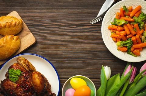 Easter food on dark rustic table pastel colored eggs roasted chicken and 스톡 사진