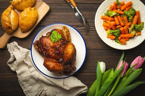 Easter food on dark rustic table pastel colored eggs roasted chicken and Foto stock