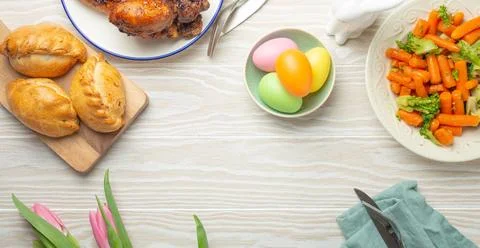 Easter food on white rustic table pastel colored eggs roasted chicken and Foto stock