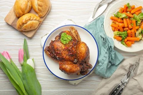 Easter food on white rustic table roasted chicken and vegetables buns and Foto stock