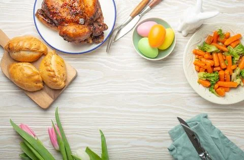Easter food on white rustic table pastel colored eggs roasted chicken and Foto stock