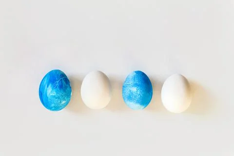 Easter frame with blue and white color eggs isolated on gray background. Stylish Stock Photos