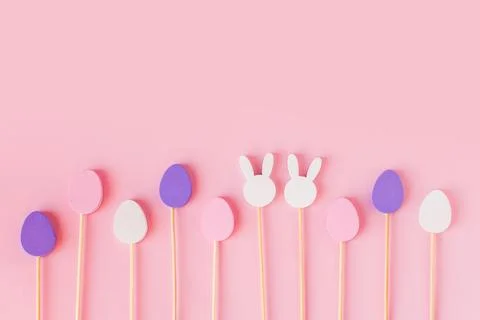 Easter frame composition with minimal style eggs and rabbit wood toys on pastel Stock Photos