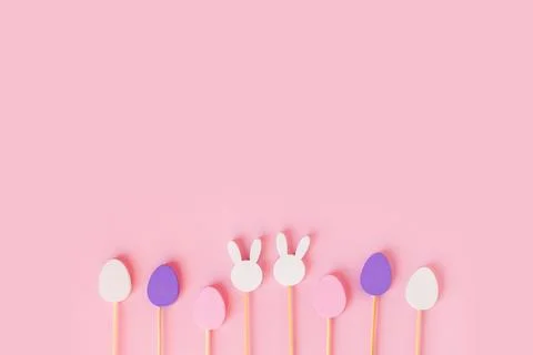 Easter frame composition with minimal style eggs and rabbit wood toys on pastel Stock Photos