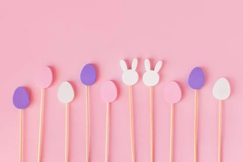 Easter frame composition with minimal style eggs and rabbit wood toys on pastel Stock Photos