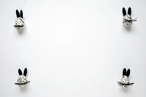 Easter frame, Easter eggs decorated as black and white bunnies on the white Stock Photos