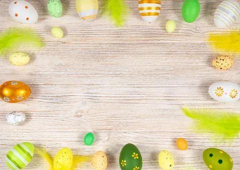 Easter frame with eggs and feathers on a light wooden background. Minimal Stock Photos