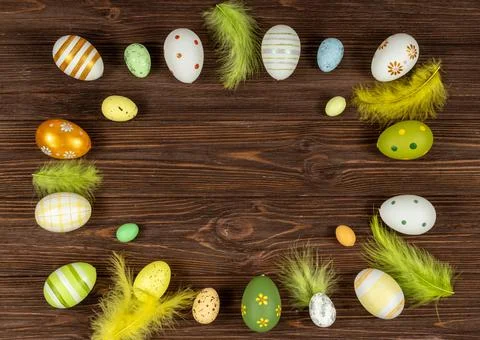 Easter frame with eggs and feathers on a dark wooden background. Minimal concept Stock Photos