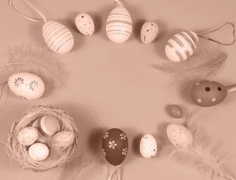 Easter frame with eggs and feathers. Demonstrating color of 2025 year mocha Stock Photos