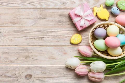 Easter frame with eggs, gift box and tulip on a colored background. The min.. Stock Photos