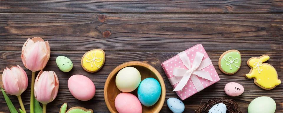 Easter frame with eggs, gift box and tulip on a colored background. The min.. Stock Photos