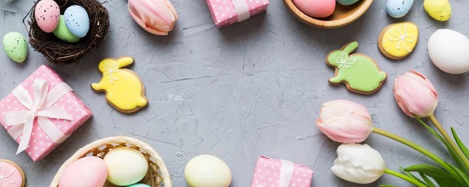 Easter frame with eggs, gift box and tulip on a colored background. The min.. Stock Photos