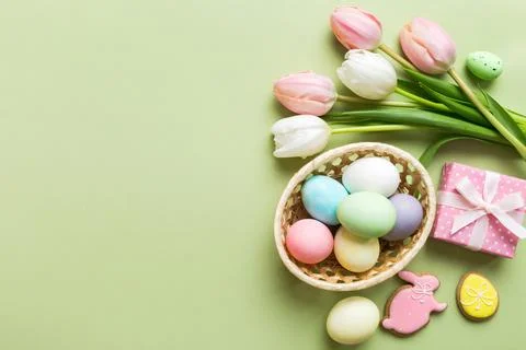 Easter frame with eggs, gift box and tulip on a colored background. The min.. Stock Photos