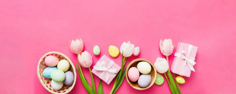Easter frame with eggs, gift box and tulip on a colored background. The min.. Stock Photos