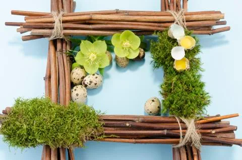 Easter frame with two raw quail eggs up and many down and two hellebore flowe Stock Photos