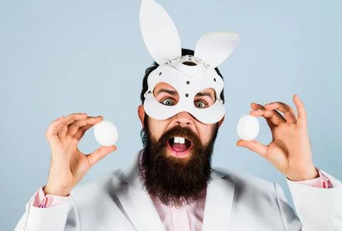 Easter funny man. Surprised guy in bunny mask with eggs. Egg hunt. Foto stock