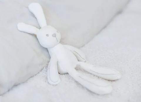 Easter funny white stuffed rabbit toy on the white bed zero west. Natural Stock Photos
