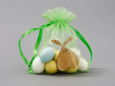 Easter gift bag with pastel eggs and wooden bunny decoration Stock Photos
