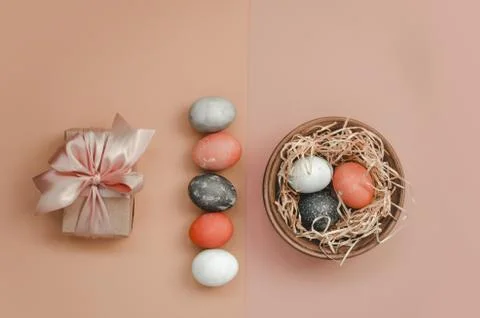 Easter gift, line of Easter eggs and nestle with eggs on yellow and pink back Stock Photos