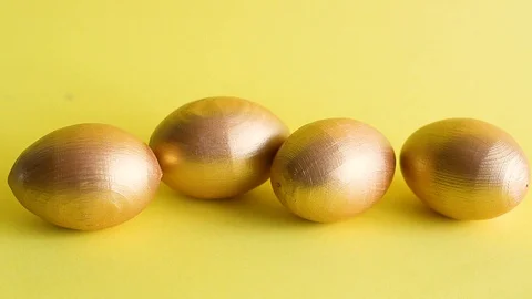 Easter gold decorative eggs on yellow background Stock Footage 128108449