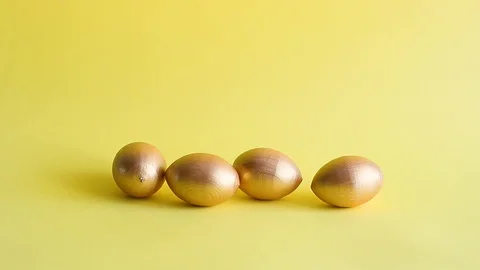 Easter gold decorative eggs on yellow background Stock Footage 128108950