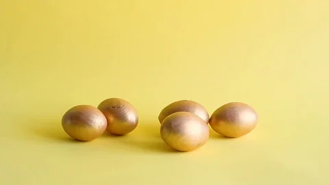 Easter gold decorative eggs on yellow background Stock Footage 128109727
