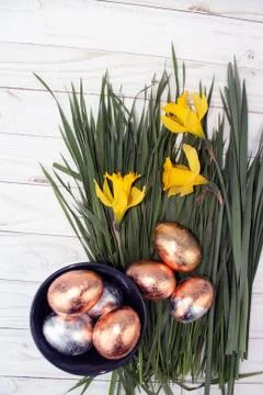Easter golden eggs and daffodils on wood background Stock Photos