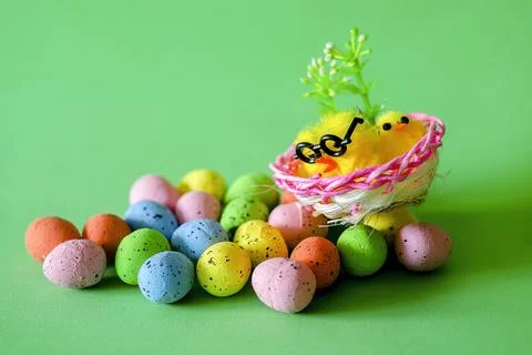 Easter greetin card with Easter eggs and chickens in a basket on green Stock Photos