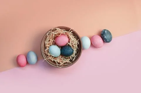 Easter greeting background with dyed multicolored chicken eggs on straw in plate Stock Photos