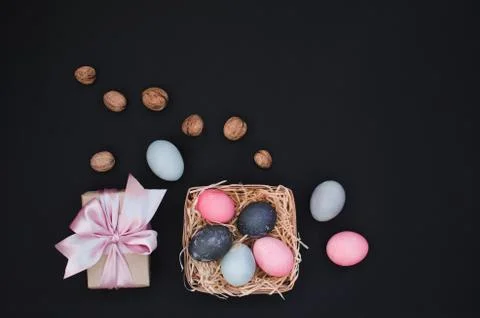 Easter greeting background with dyed multicolored chicken quail eggs on straw in Stock Photos